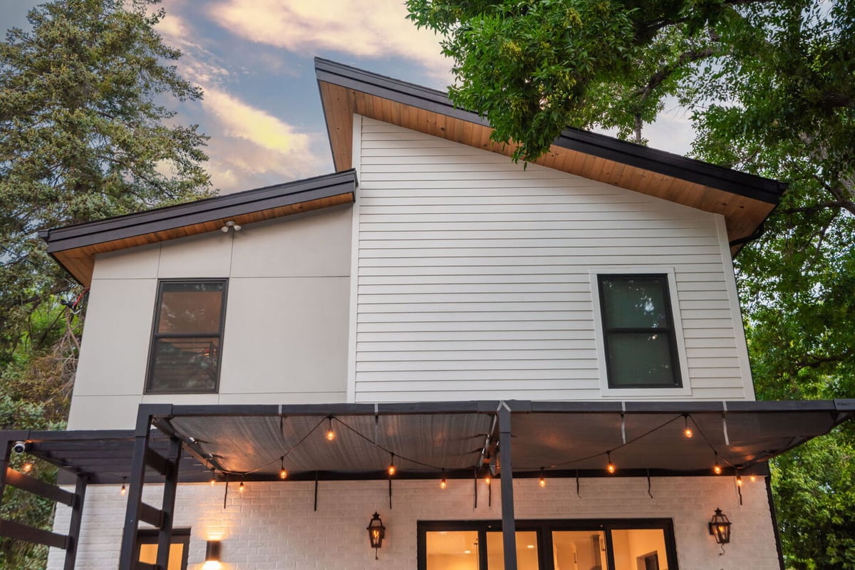 Denver pop top renovation exterior with covered patio, string lights, and modern siding, built by Cillessen Construction