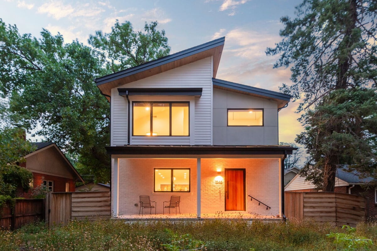 Denver pop top renovation front exterior with lit porch, wood entry door, and clean modern lines in Denver by Cillessen Construction
