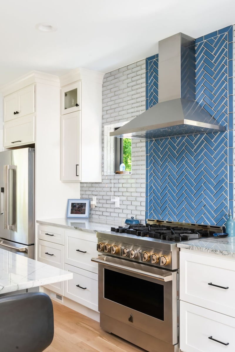 Denver pop top renovation kitchen with stainless range, white cabinets, and blue tile backsplash by Cillessen Construction