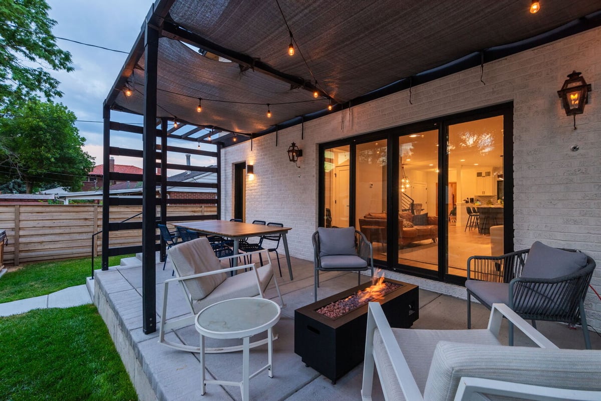 Denver pop top renovation patio seating with fire table, string lights, and sliding doors by Cillessen Construction