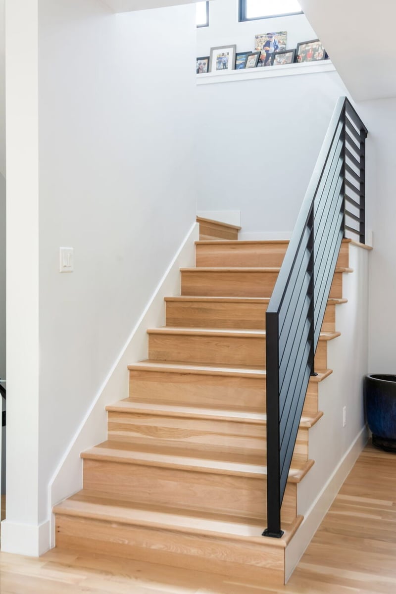 Denver pop top renovation staircase with wood treads and black metal railing, bright modern interior by Cillessen Construction