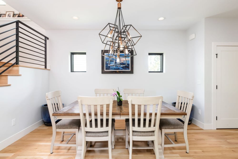Denver pop top renovation dining room with wood table, white chairs, and modern geometric chandelier by Cillessen Construction