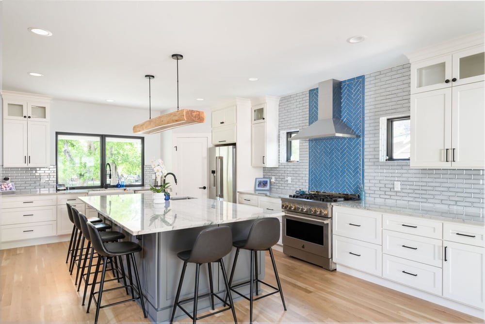 Denver pop top renovation kitchen with marble island, white cabinets, stainless appliances, and blue tile by Cillessen Construction