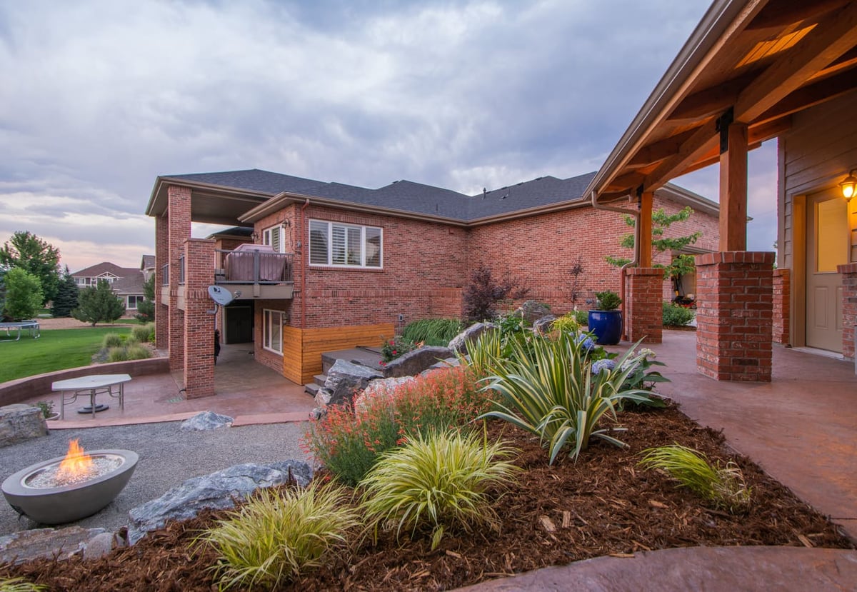 Covered patio and garden beds overlooking fire pit area near garage build in Arvada, CO by Cillessen Construction