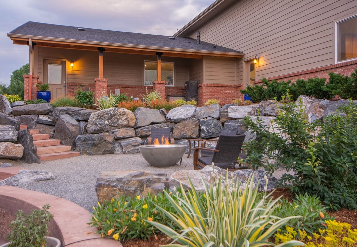 Covered patio and landscaped yard with fire pit near garage build in Arvada, CO by Cillessen Construction