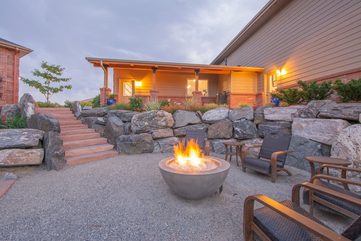 Fire pit with seating and stone steps leading to patio near garage build in Arvada, CO by Cillessen Construction
