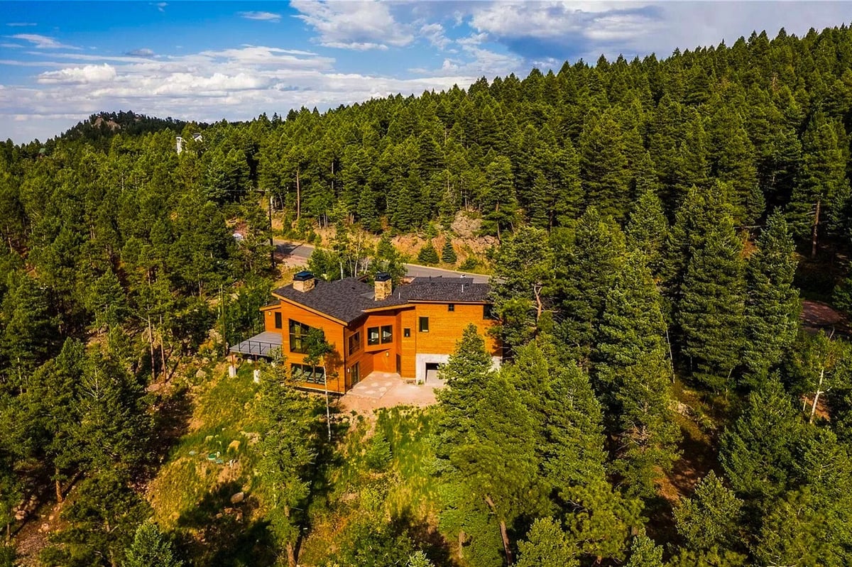 denver-colorado-aerial-view-of-modern-home-by-cillessen-construction-company-in-wooded-mountain-terrain-with-road-access