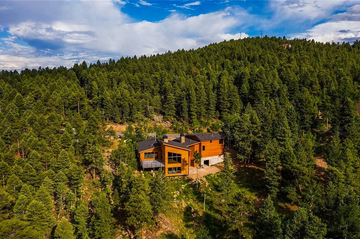 denver-colorado-modern-home-exterior-by-cillessen-construction-company-with-warm-wood-siding-and-attached-garage-at-dusk