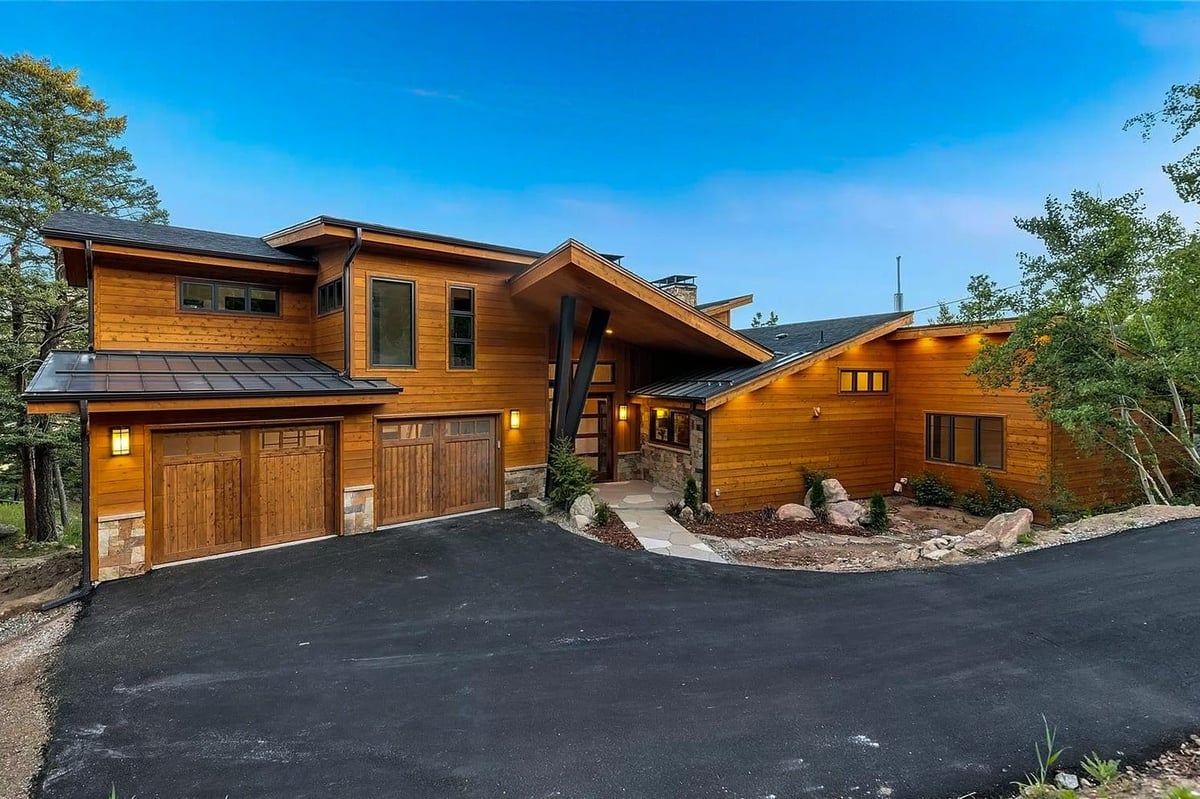denver-colorado-modern-mountain-home-exterior-by-cillessen-construction-company-with-wood-siding-and-three-car-garage