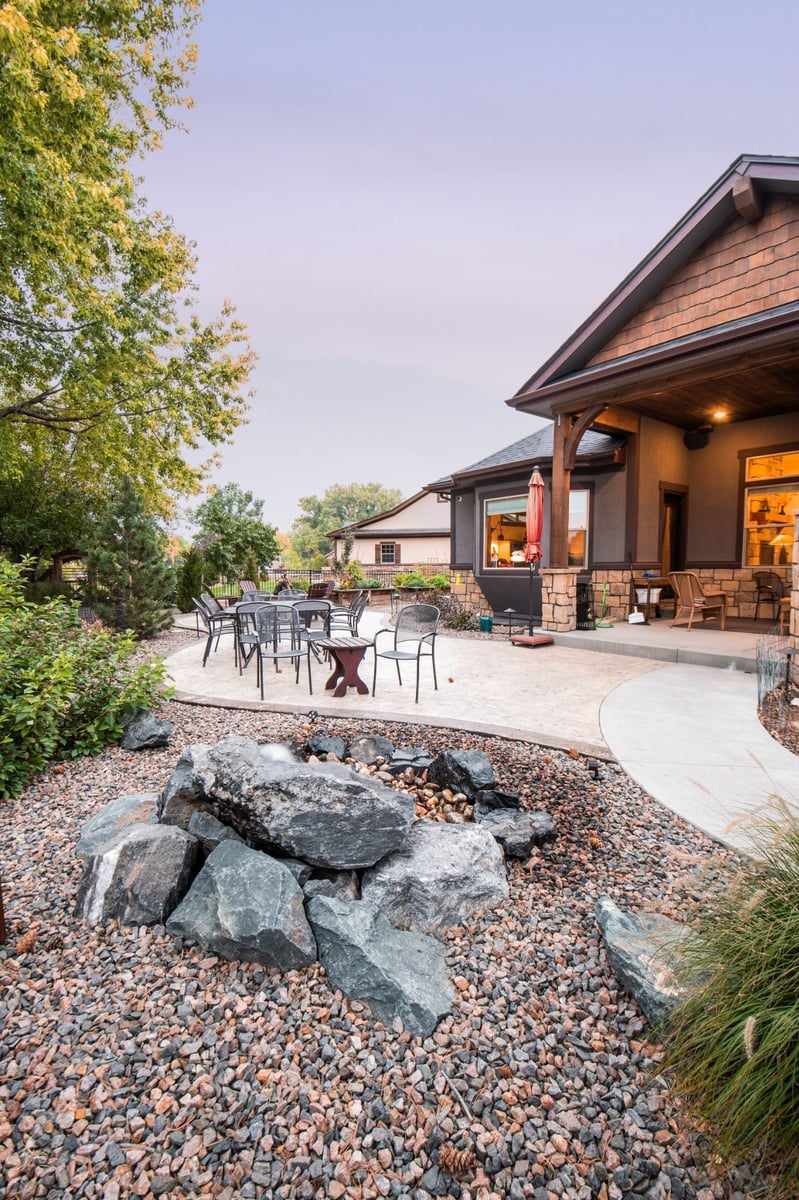 backyard patio with curved concrete seating area and landscaping for exterior renovation in denver colorado