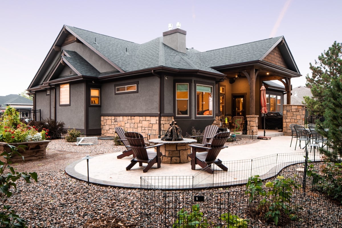 covered outdoor living space with patio furniture and stone columns for exterior renovation in denver colorado