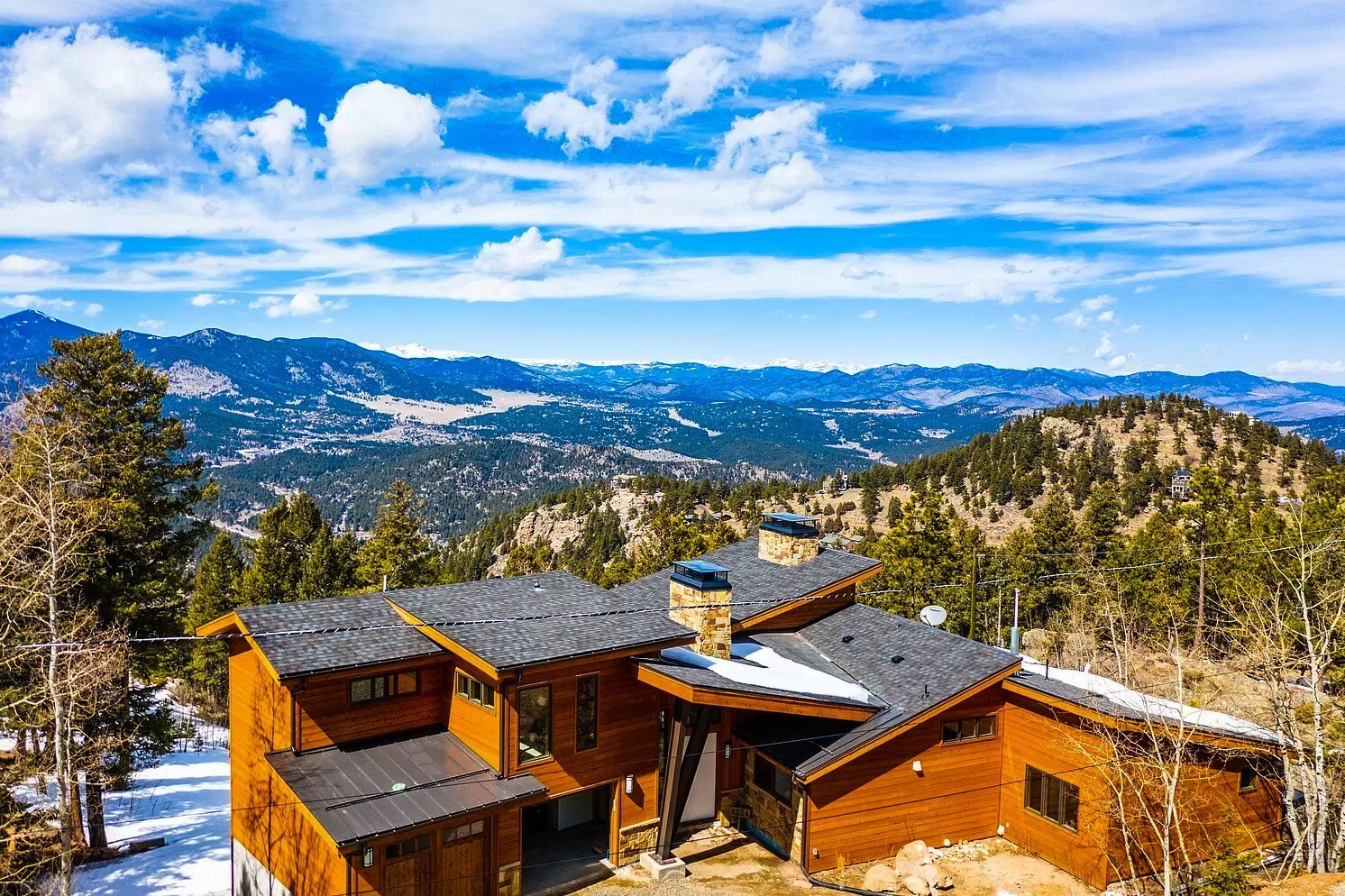 denver-colorado-aerial-view-of-modern-mountain-home-by-cillessen-construction-company-surrounded-by-pine-forest-and-snow