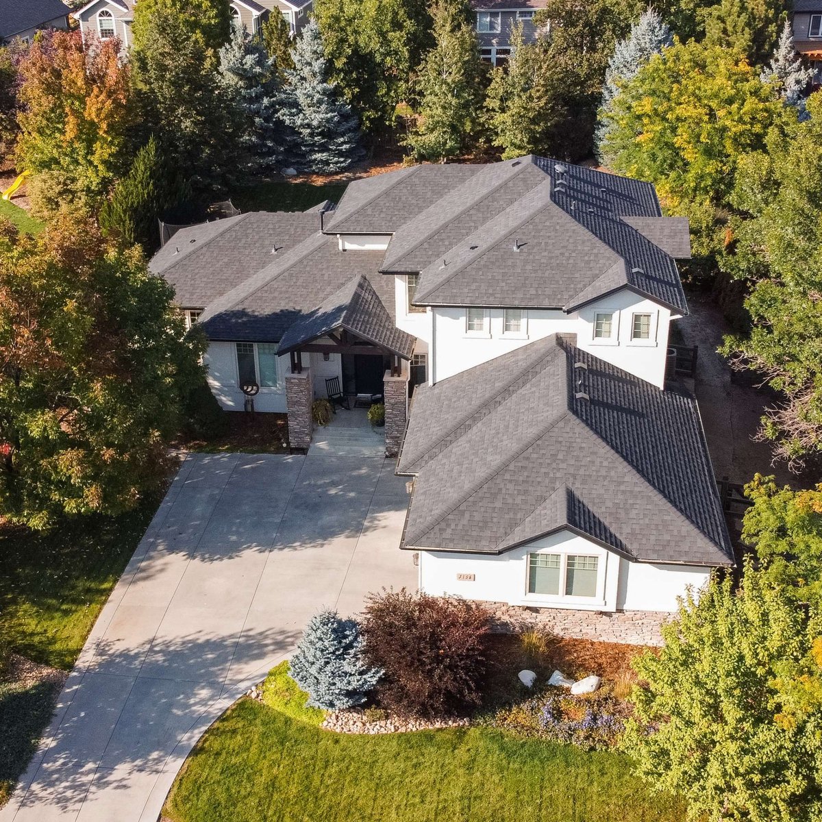 aerial view of large residential home with new roof exterior restoration in denver colorado surrounded by mature trees