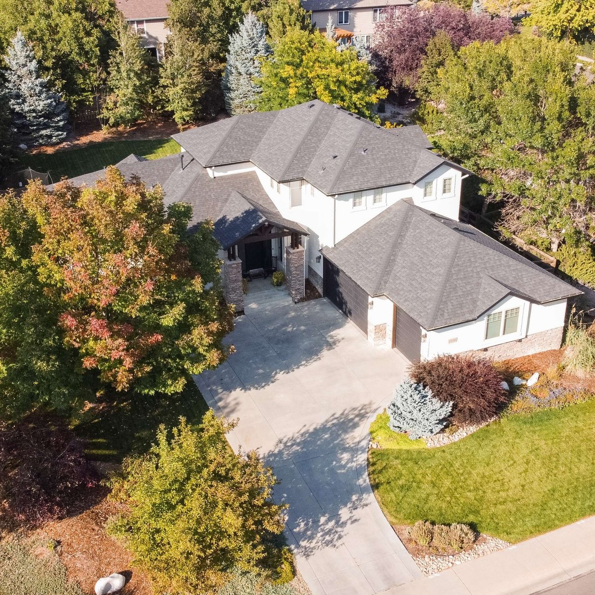 angled aerial view of house with new asphalt shingle roof exterior restoration in denver colorado and tree lined neighborhood