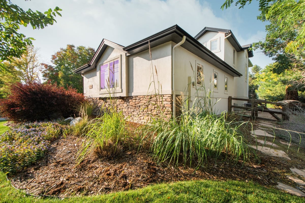 angled backyard perspective of home with exterior restoration roofing in denver colorado and green lawn