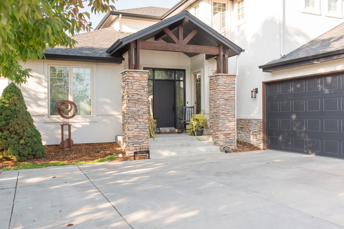 front entry of home with stone columns and exterior restoration roofing in denver colorado