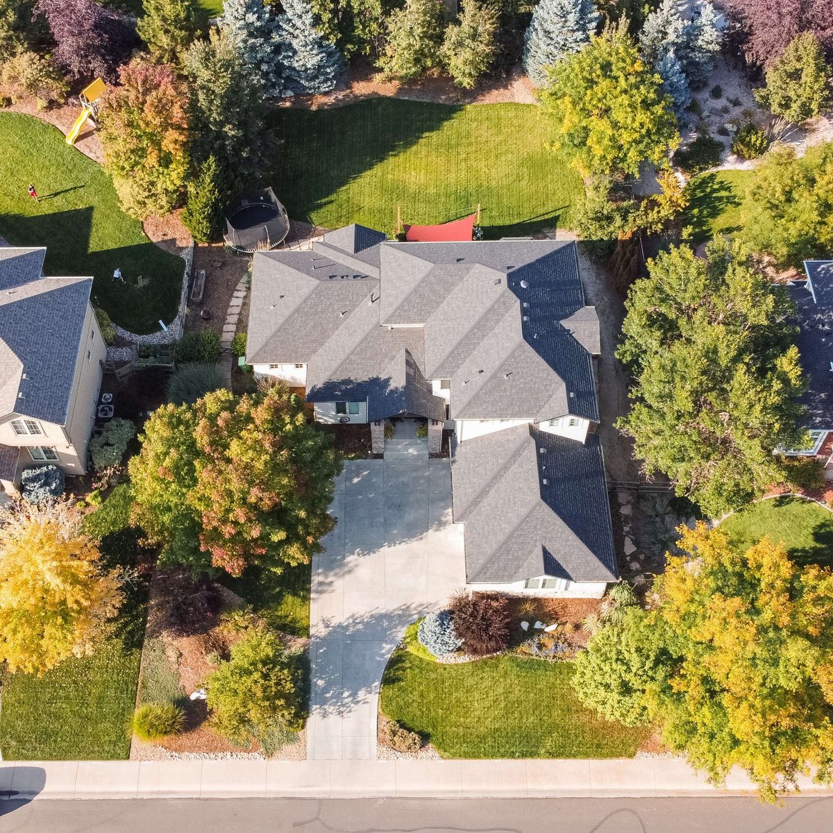 overhead drone perspective of residential exterior restoration roofing project in denver colorado with backyard lawn and trees