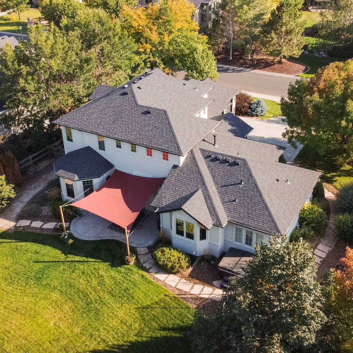 rear aerial view of home with exterior restoration roofing in denver colorado showing patio area and surrounding greenery