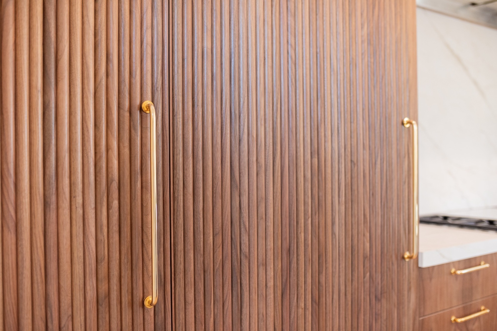 fluted walnut cabinetry with brass hardware in applewood village pop top renovation