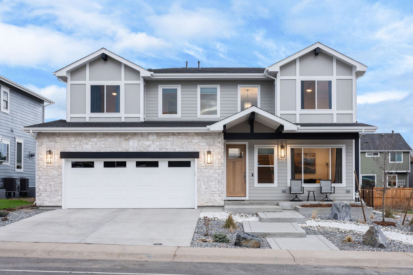 Louisville, CO custom home front elevation with symmetrical windows, stone accents, and landscaped entry by Cillessen Construction