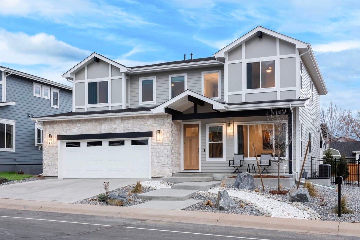 Louisville, CO custom home exterior with stone facade, double garage, and modern gable design by Cillessen Construction