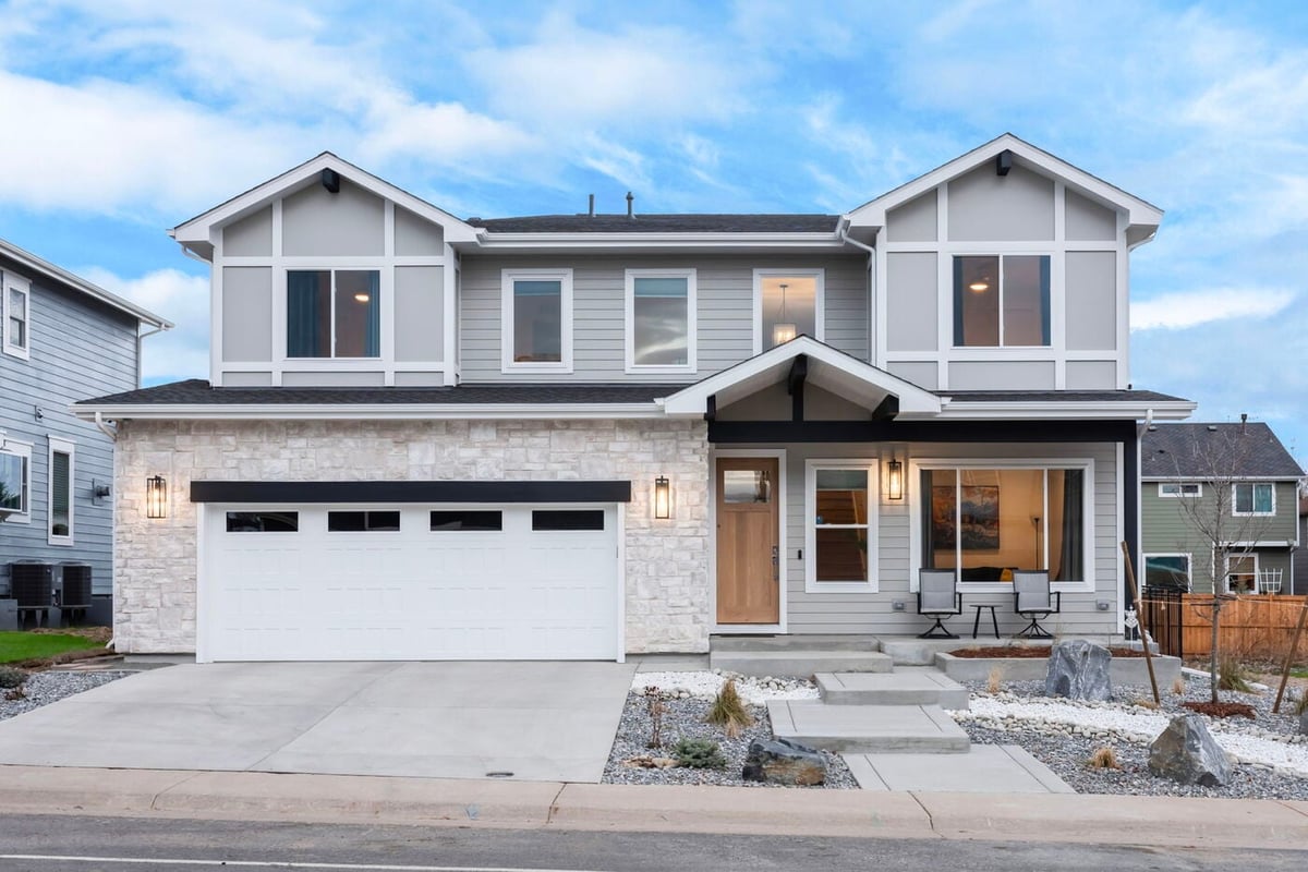 Louisville, CO custom home front elevation with symmetrical windows, stone accents, and landscaped entry by Cillessen Construction