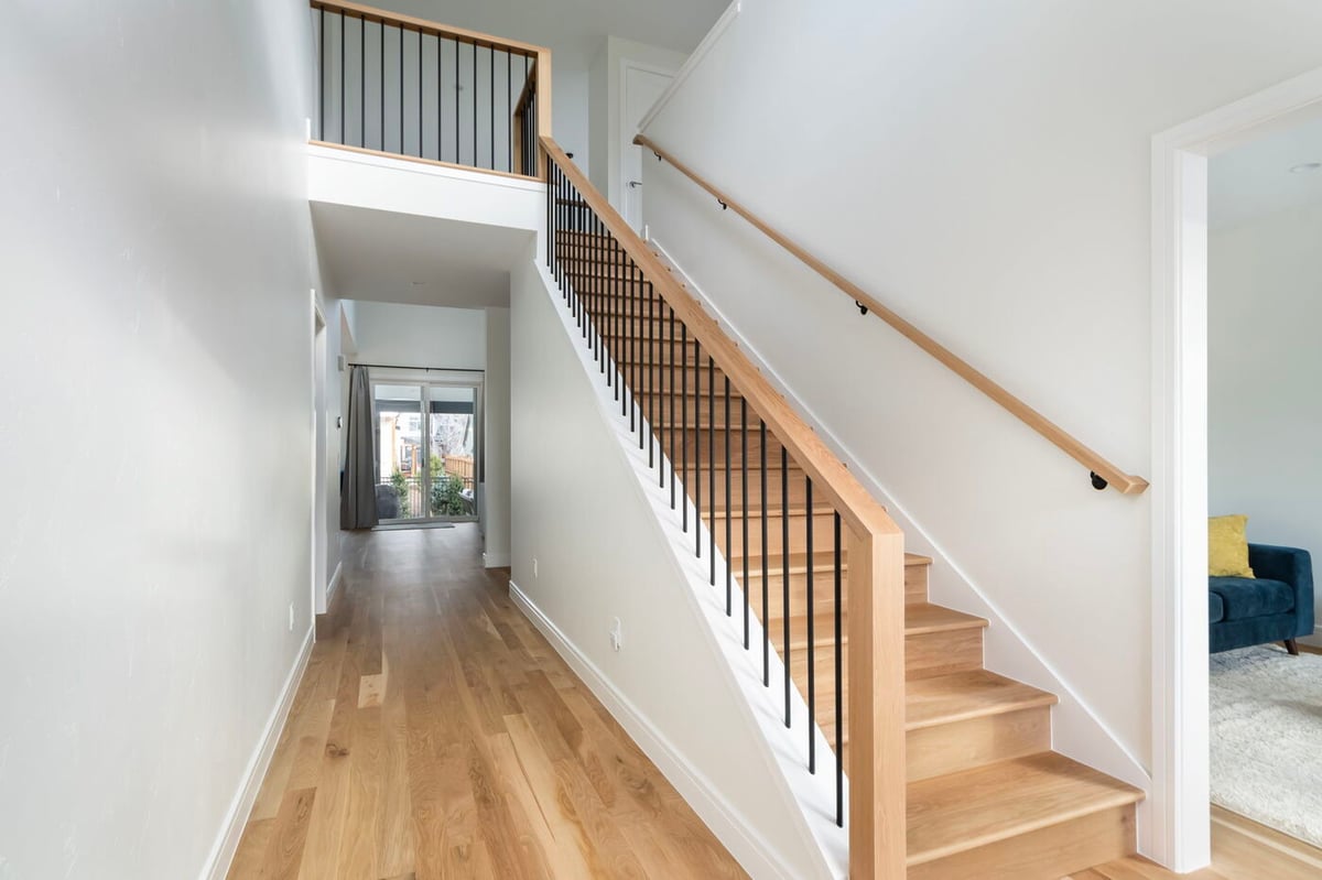 Louisville, CO custom home hallway with staircase and wood flooring by Cillessen Construction
