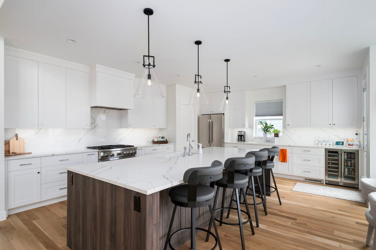Louisville, CO custom home kitchen with large island, pendant lighting, and white cabinetry by Cillessen Construction