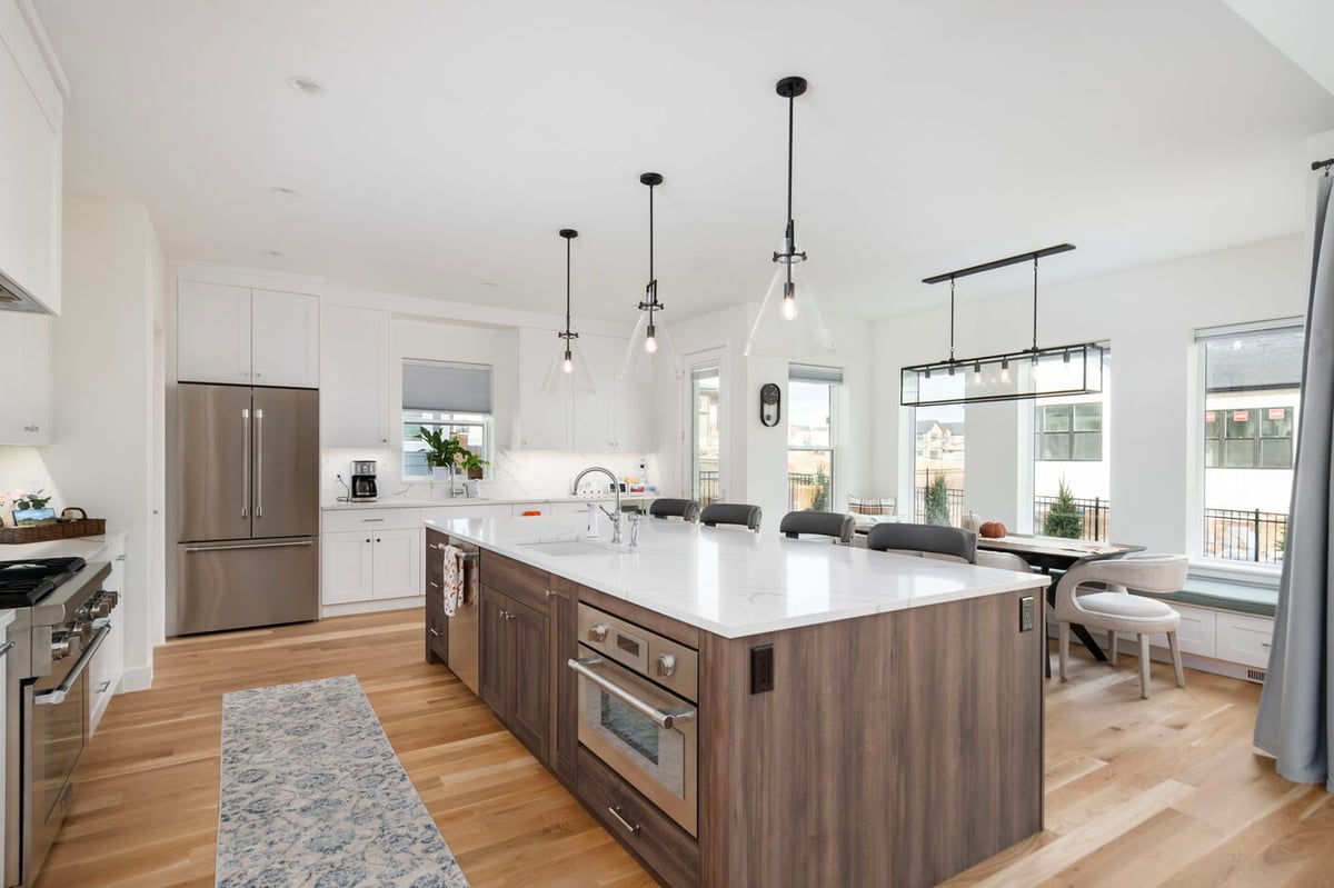 Louisville, CO custom home kitchen with large island, pendant lights, and open layout by Cillessen Construction