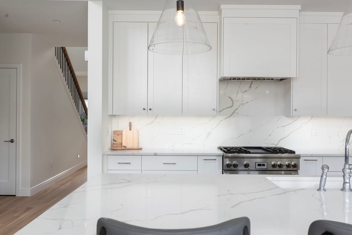 Louisville, CO custom home kitchen with quartz counters, white cabinets, and gas range by Cillessen Construction