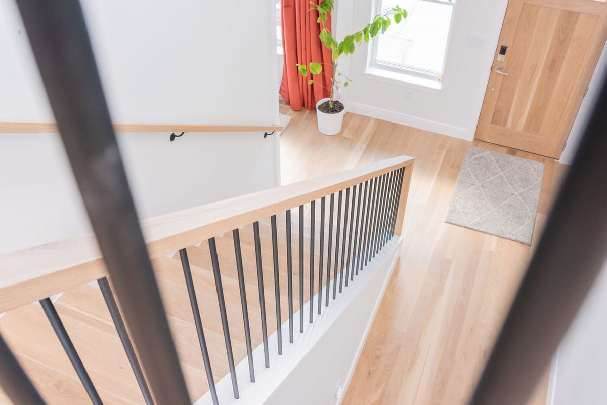 Louisville, CO custom home stair landing with wood floors and modern railing by Cillessen Construction