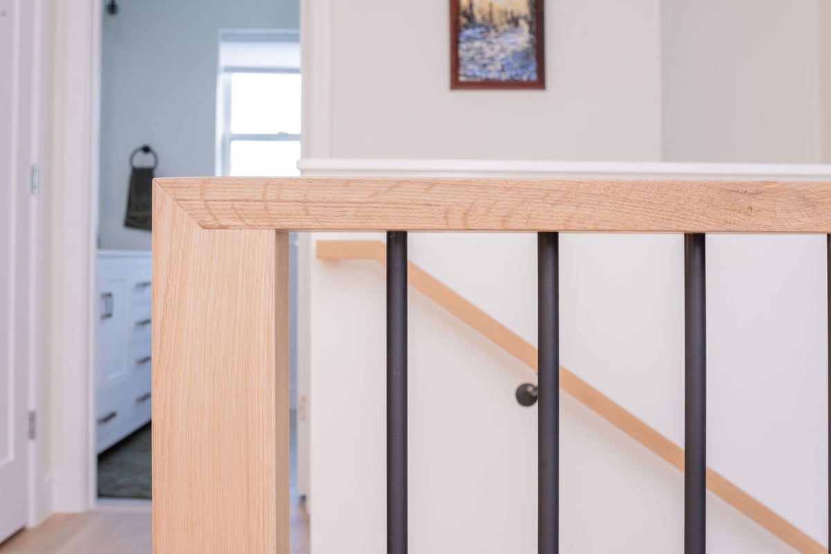 Louisville, CO custom home stair railing detail with wood and black balusters by Cillessen Construction