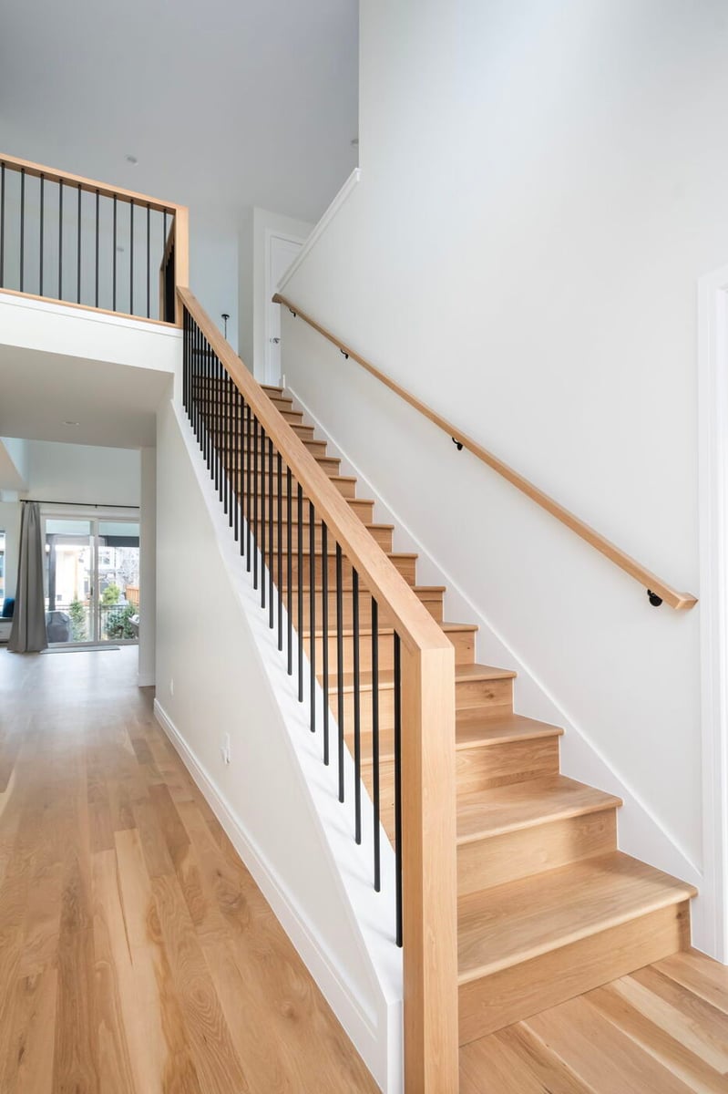 Louisville, CO custom home staircase with wood treads and modern black railing by Cillessen Construction