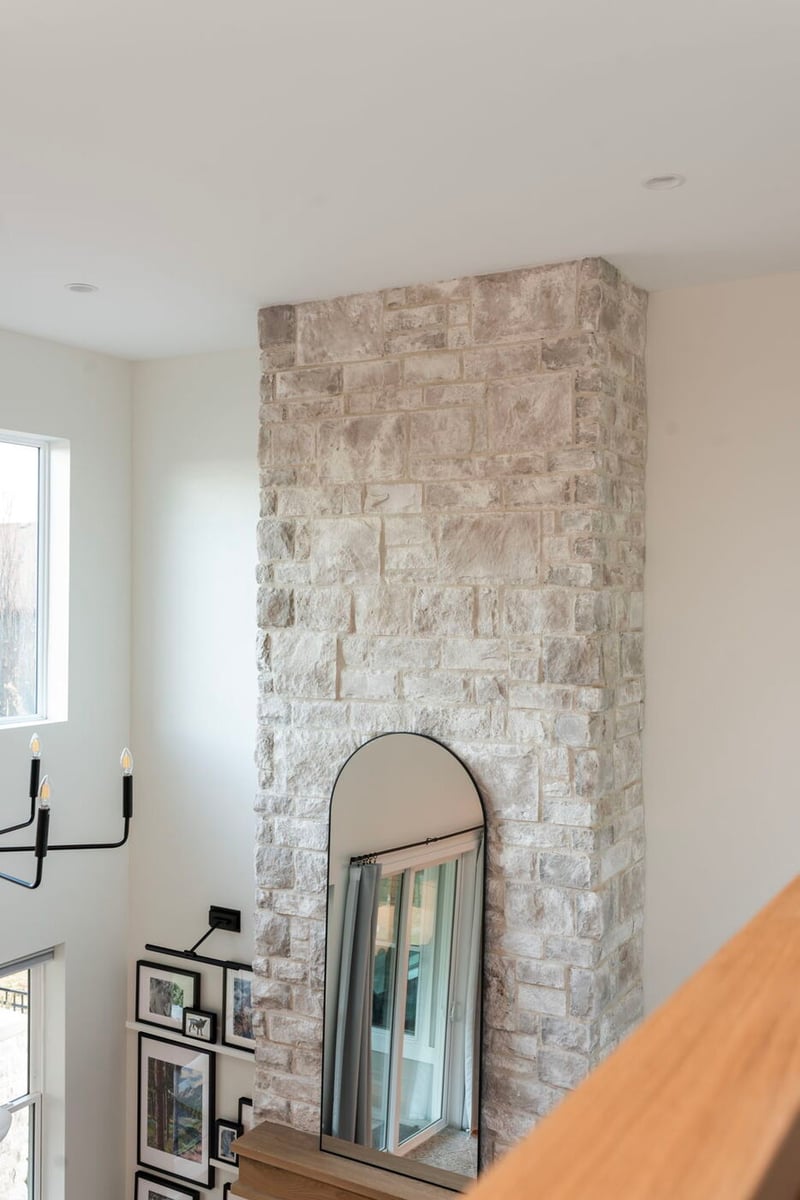 Louisville, CO custom home stone fireplace with tall ceiling and mirror detail by Cillessen Construction