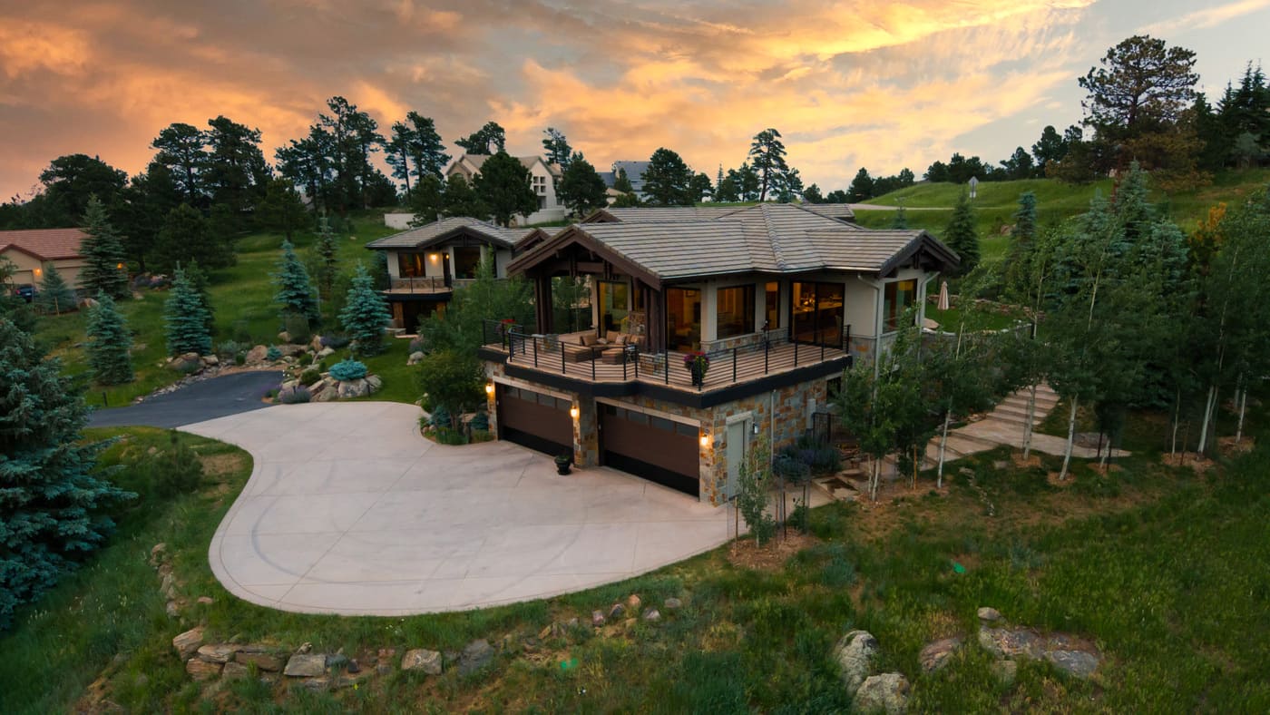 Genesee, CO renovation aerial at sunset with deck, garage, and landscaped hillside by Cillessen Construction