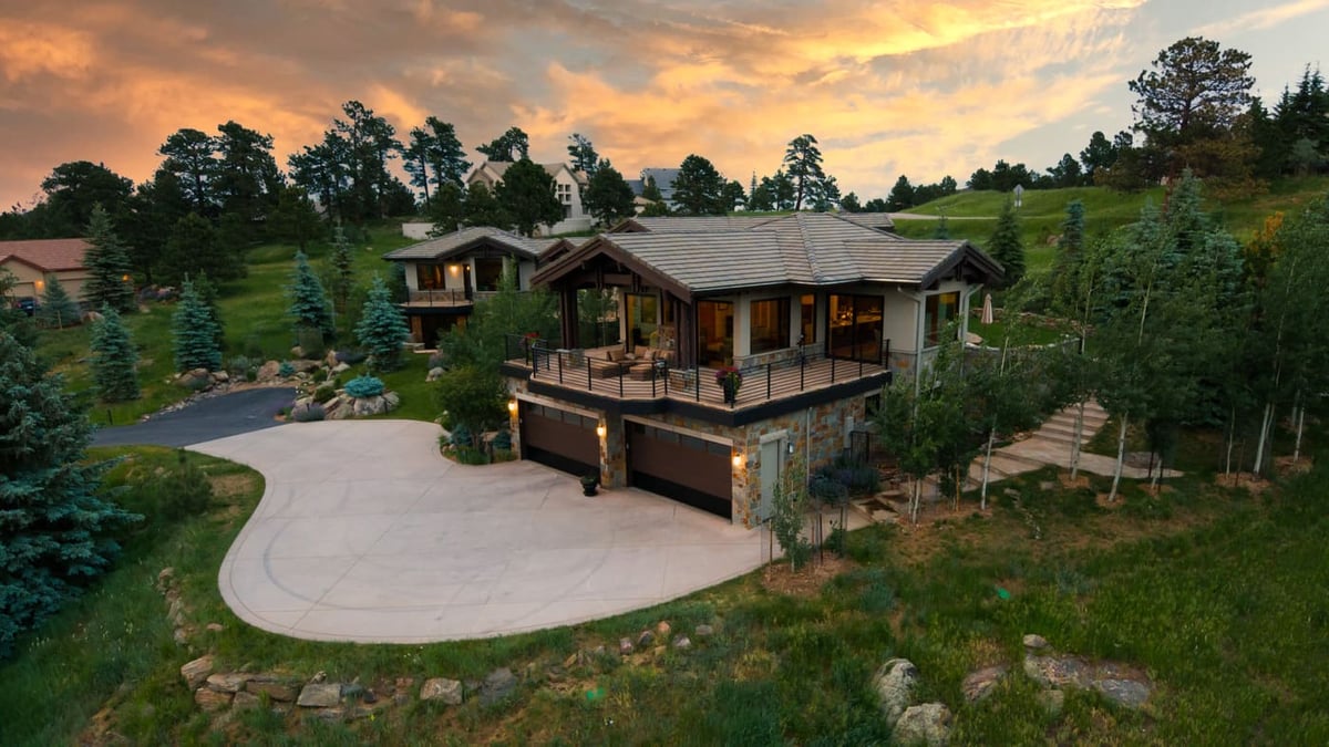 Genesee, CO renovation aerial at sunset with deck, garage, and landscaped hillside by Cillessen Construction