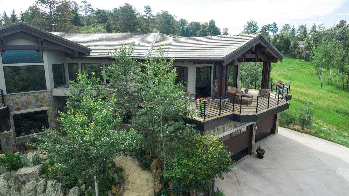 Genesee, CO renovation aerial of home with balcony, stone exterior, and driveway by Cillessen Construction