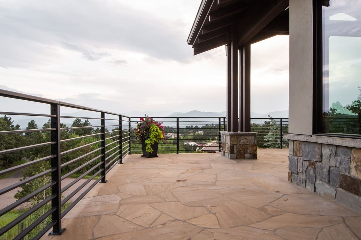 Genesee, CO renovation balcony with stone flooring, railing, and mountain views by Cillessen Construction