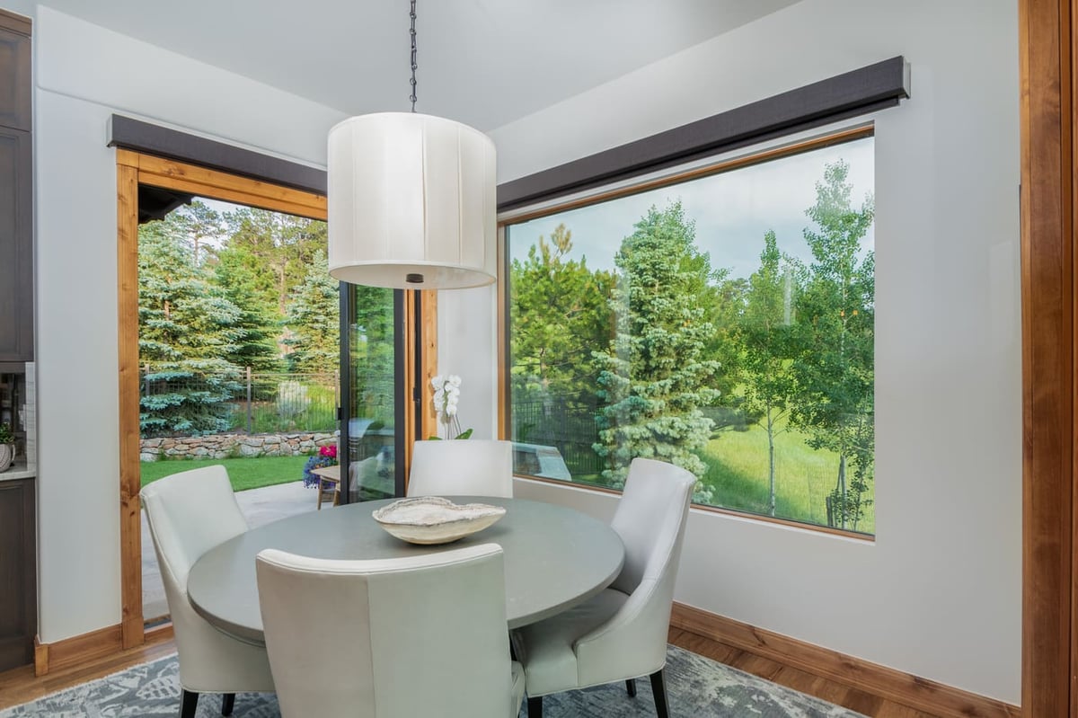 Genesee, CO renovation breakfast nook with large corner windows and greenery views by Cillessen Construction