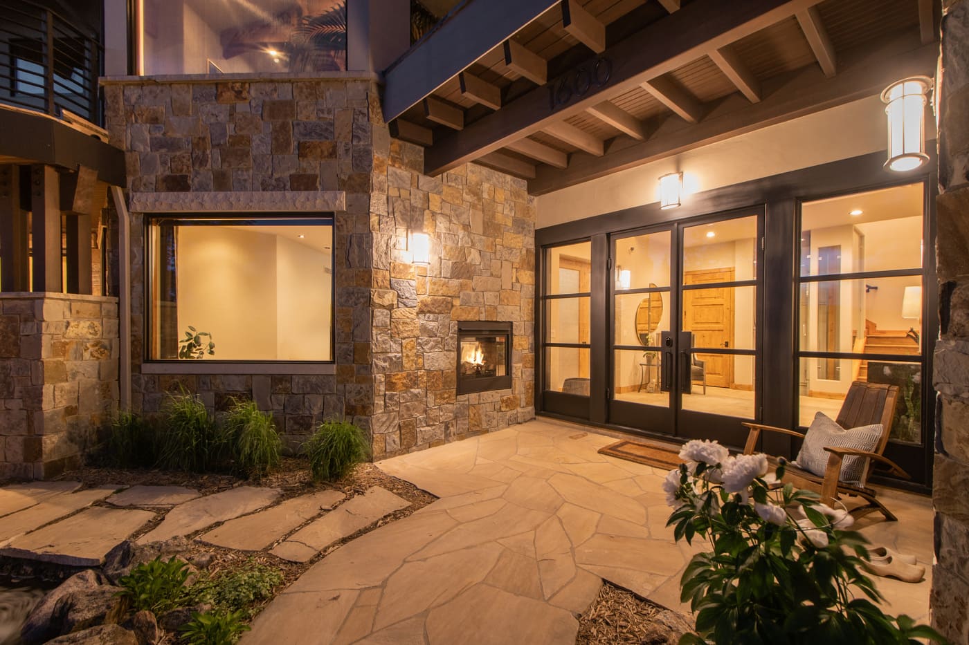 Genesee, CO renovation entry patio with stone walls, fireplace, and glass doors by Cillessen Construction