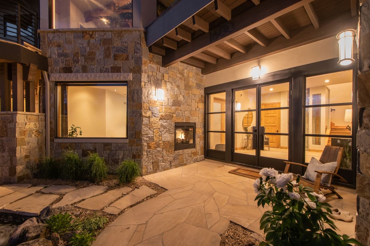 Genesee, CO renovation entry patio with stone walls, fireplace, and glass doors by Cillessen Construction