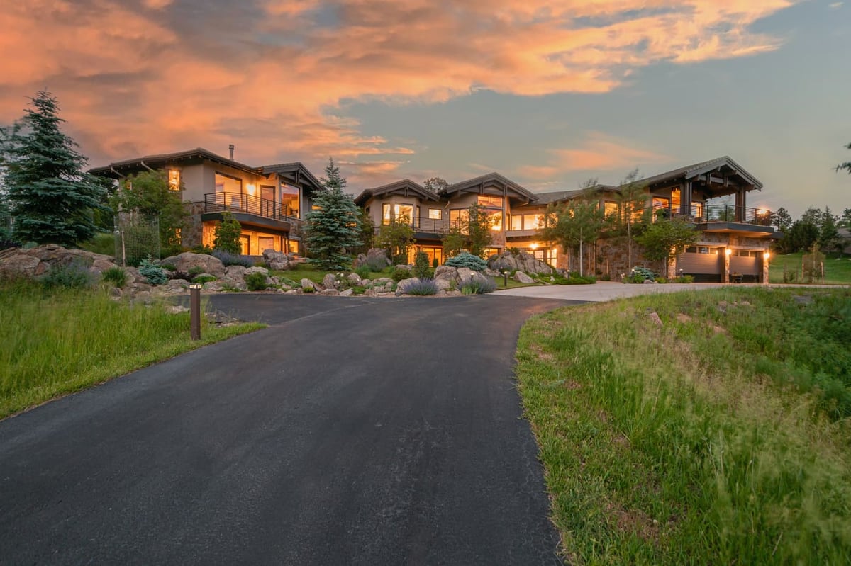 Genesee, CO renovation exterior with winding driveway and mountain home at sunset by Cillessen Construction