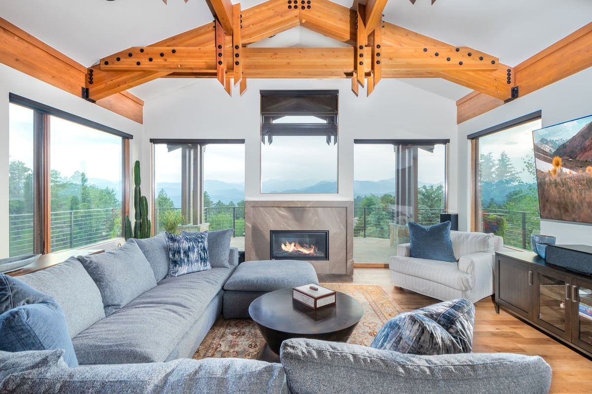 Genesee, CO renovation living room with timber beams, fireplace, and mountain views by Cillessen Construction