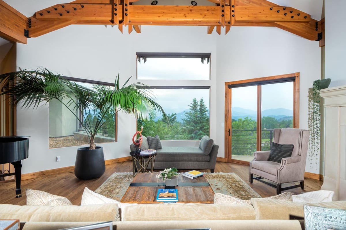 Genesee, CO renovation living room with timber beams, large windows, and scenic views by Cillessen Construction