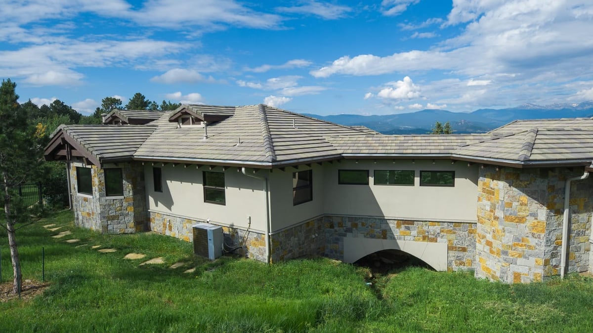 Genesee, CO renovation rear exterior with stonework, stucco, and mountain views by Cillessen Construction