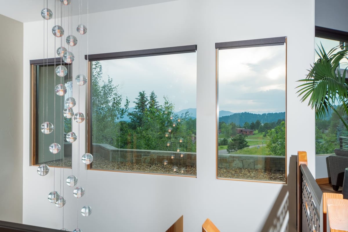 Genesee, CO renovation stair landing with modern chandelier and mountain views by Cillessen Construction