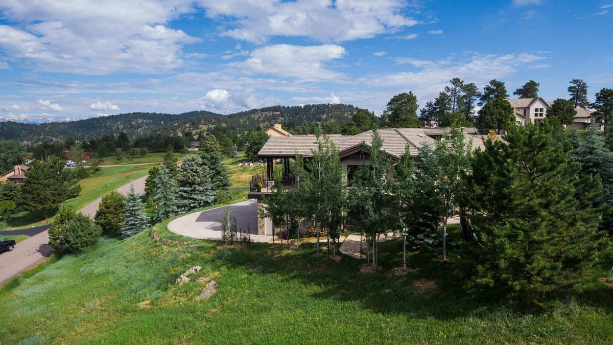 Genesee, CO renovation wide aerial with curved driveway and wooded surroundings by Cillessen Construction