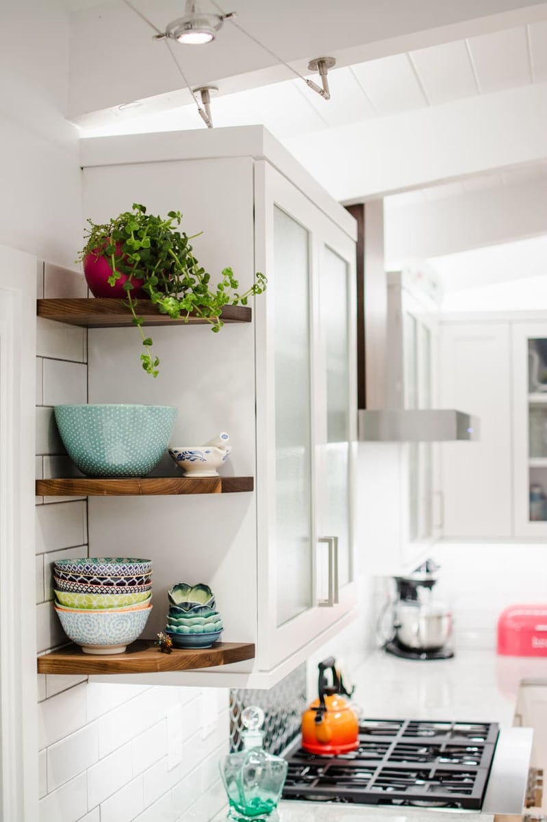 Applewood, CO kitchen renovation with open shelving, white cabinets, and decor accents by Cillessen Construction