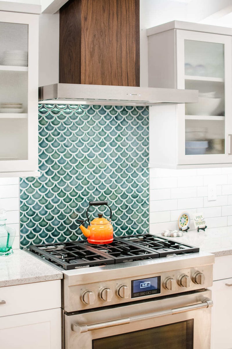 Applewood, CO kitchen renovation with stainless range, teal fish scale backsplash, and wood hood by Cillessen Construction
