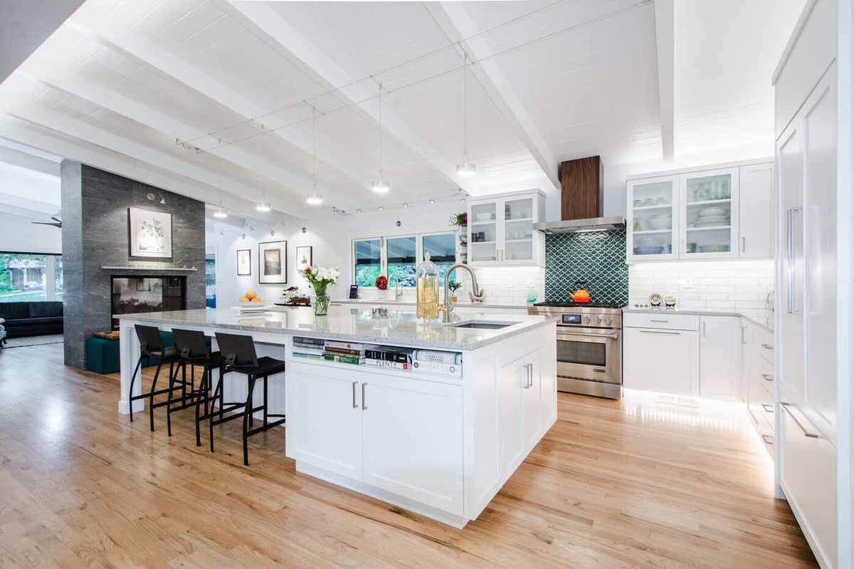 Applewood, CO renovation bright kitchen with island, pendant lighting, and open layout by Cillessen Construction